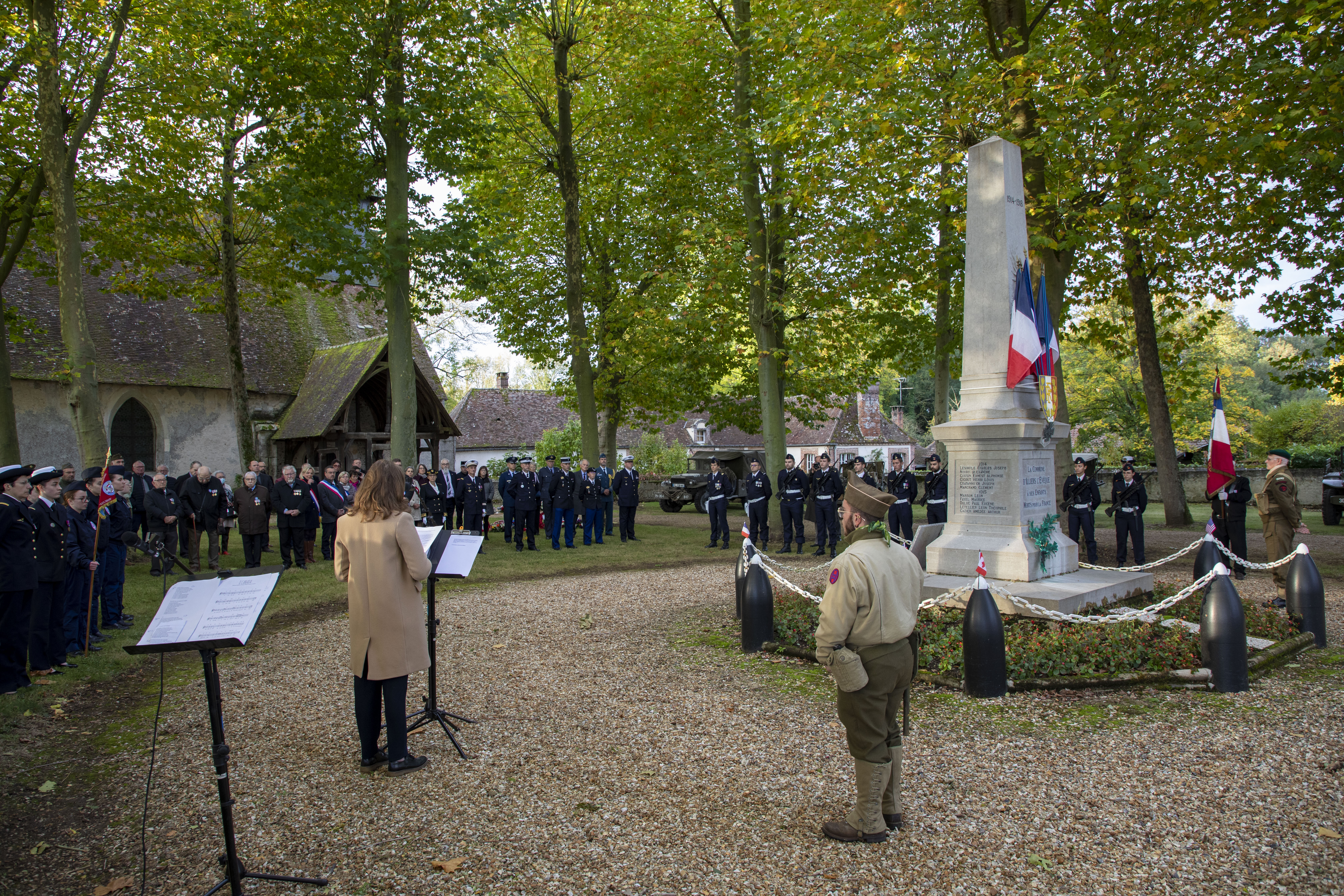Personnel and attendants stand by memorial.